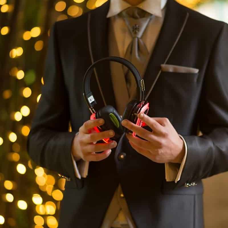 matrimonio Marié en costume élégant tenant des casques Silent Disco