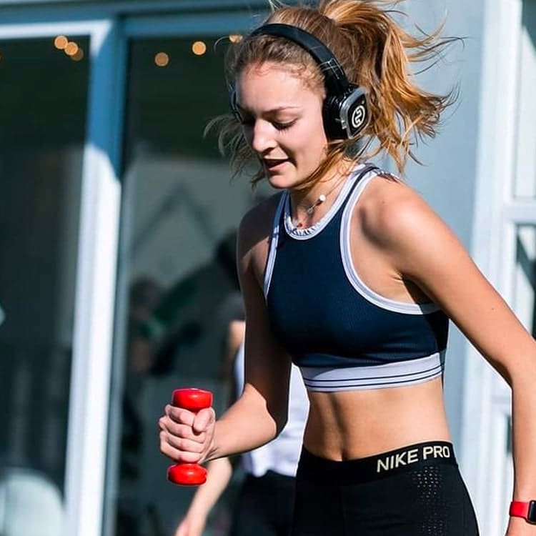 weight-capo Jeune femme s'entraînant avec des poids et un casque sans fil