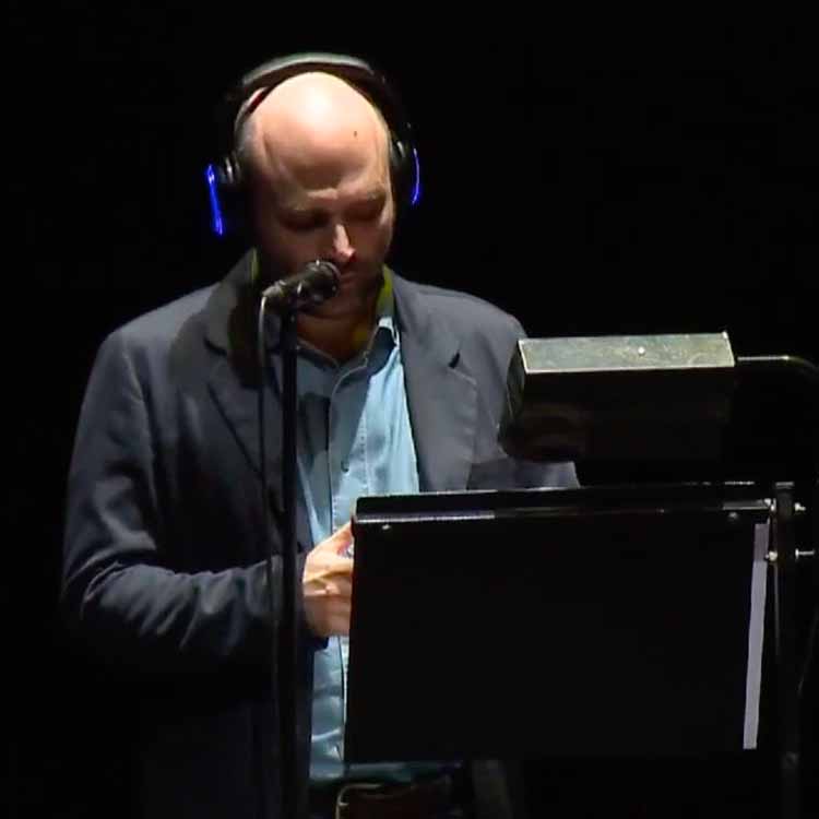 saviano-piccolo-teatro Roberto Saviano leest voor aan een lessenaar met hoofdtelefoon van Silentsystem in het Piccolo Teatro
